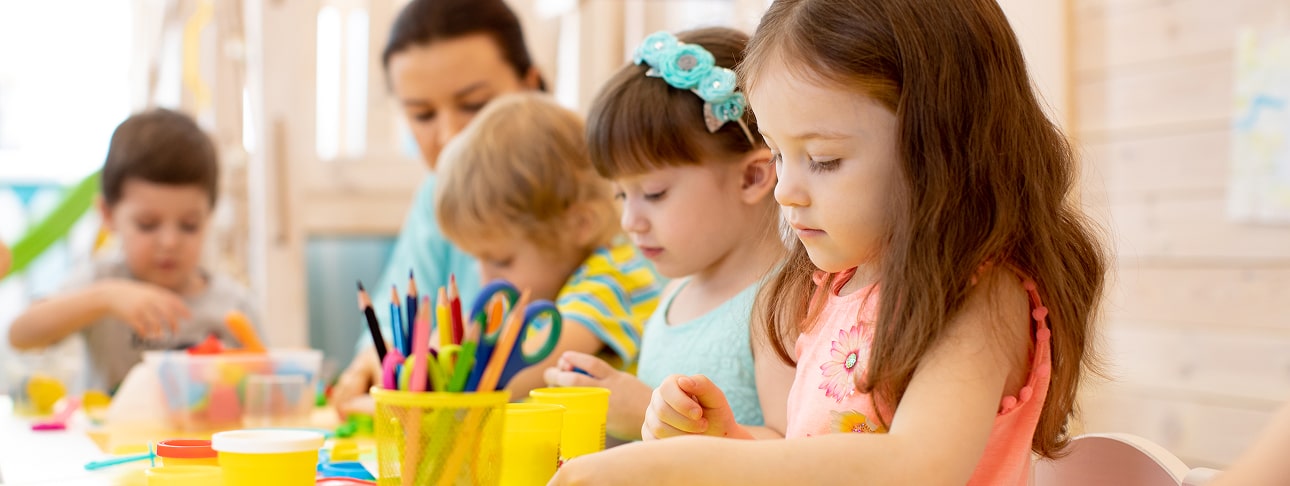 Children and teacher crafting with colorful supplies.